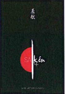 Su sfondo nero, disegno composto da due ideogrammi giapponesi, mezzo sole rosso con inserimento della parola SA in colore bianco, Su sfondo nero, disegno composto da due ideogrammi giapponesi, mezzo sole rosso con inserimento della parola SA in colore bianco, separato da una pennellata bianca, seguita dalla parola kén, in calce in colore bianco la descrizione SAKE METODO CLASSICO Su sfondo nero, disegno composto da due ideogrammi giapponesi, mezzo sole rosso con inserimento della parola SA in colore bianco