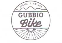 GUBBIO BIKE IL LOGO VIENE RAPPRESENTATO CON UN CERCHIO DI COLOR MARRONE GB DIVISO IN TRE SEZIONI INTERNE, NELLA PARTE ALTA GUBBIO BIKE LOGO VIENE RAPPRESENTATO CON UN CERCHIO DI COLOR MARRONE GB DIVISO IN TRE SEZIONI INTERNE, NELLA PARTE ALTA ALL INTERNO DEL CERCHIO VI SONO LE PAROLE STORIA NATURA IN STAMPATELLO CON AL DI SOTTO DI ESSE LA STILIZZAZIONE DI MONTAGNE, NELLA PARTE CENTRALE DEL CERCHIO VI E LA SCRITTA GUBBIO IN STAMPATELLO AL DI SOTTO DI ESSA LA PAROLA bike IN CORSIVO TUTTO DI COLOR MARRONE GB, NELLA SEZIONE IN BASSO SEMPRE ALL INTERNO DEL CERCHIO VI E LA STILIZZAZIONE DI RAGGI DELLA RUOTA DI UNA BICICLETTA GUBBIO BIKE