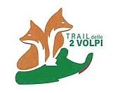 marchio consiste nella dicitura TRAIL delle 2 VOLPI trad.:sentiero delle 2 volpi, posizionata su due righe e marchio consiste nella dicitura TRAIL delle 2 VOLPI trad.:sentiero delle 2 volpi, posizionata su due righe e di colore verde, alla sinistra della quale compaiono le sagome di due volpi di colore marrone con collo ed occhio bianco, appoggiate alla forma stilizzata di una calzatura di colore verde scuro, con bordo sottostante di colore verde, bianco e rosso. Il marchio consiste nella dicitura TRAIL delle 2 VOLPI trad.:sentiero delle 2 volpi, posizionata su due righe e